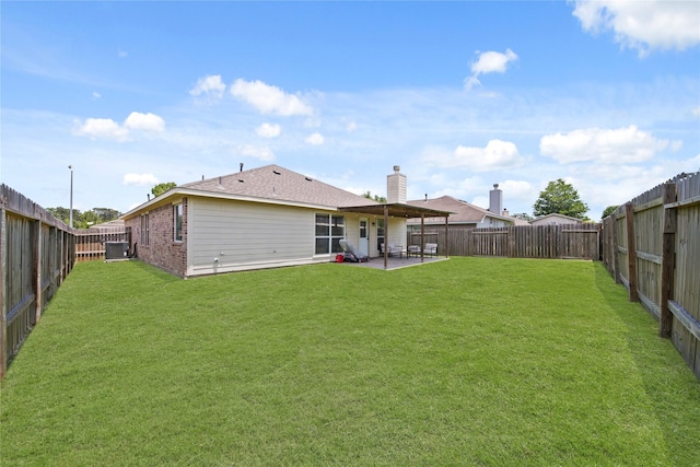 1111 Cypress Ln, Dayton, TX 77535 - back of property with a patio, a fenced backyard, and brick siding