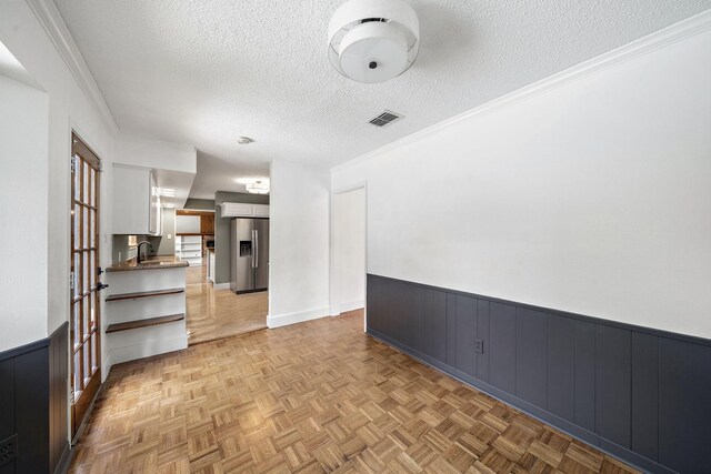 12239 Monticeto Ln, Meadows Place, TX 77477 - spare room with a textured ceiling, a wainscoted wall, and crown molding