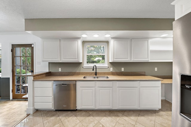 12239 Monticeto Ln, Meadows Place, TX 77477 - kitchen with stainless steel appliances, white cabinets, open shelves, light countertops, and a textured ceiling