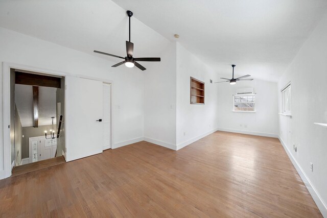 12239 Monticeto Ln, Meadows Place, TX 77477 - unfurnished living room with ceiling fan, vaulted ceiling, light wood-style floors, and a chandelier