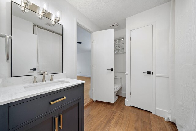 12239 Monticeto Ln, Meadows Place, TX 77477 - full bathroom featuring wood finished floors, vanity, and a textured ceiling