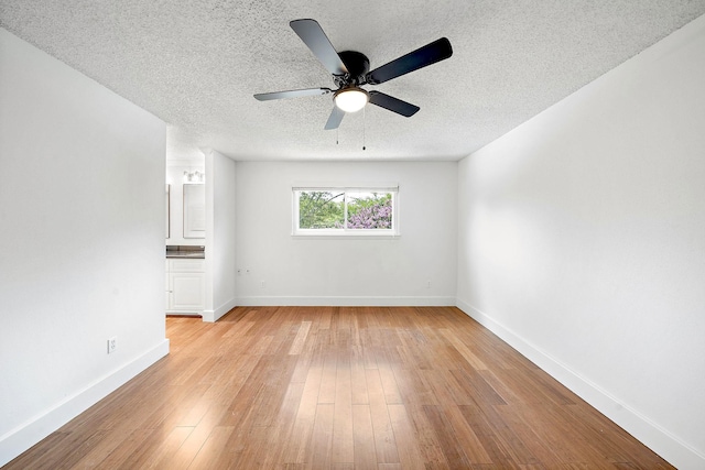 12239 Monticeto Ln, Meadows Place, TX 77477 - spare room featuring light wood-type flooring, a textured ceiling, and a ceiling fan