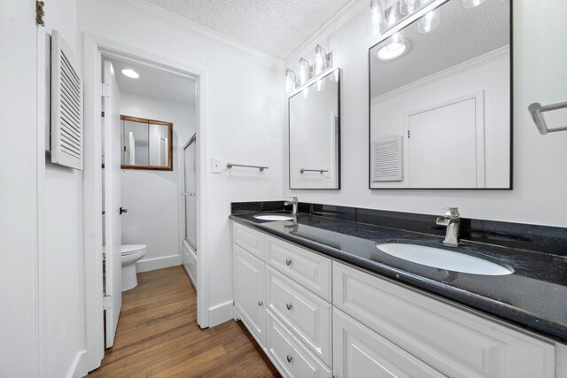 12239 Monticeto Ln, Meadows Place, TX 77477 - full bathroom featuring double vanity, crown molding, a textured ceiling, and wood finished floors