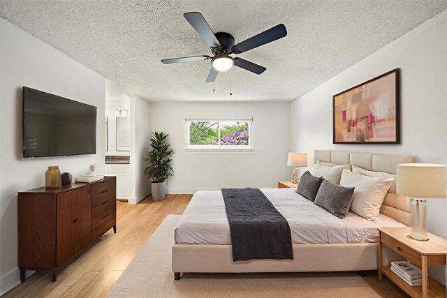 12239 Monticeto Ln, Meadows Place, TX 77477 - bedroom featuring light wood-type flooring, a textured ceiling, and a ceiling fan