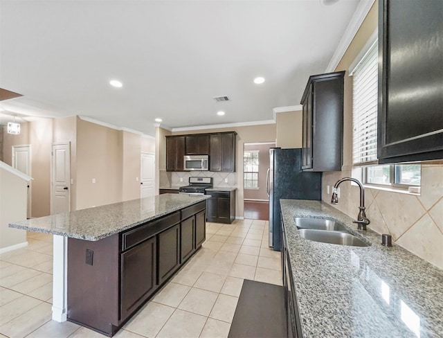 20015 Flax Flower Dr, Richmond, TX 77407 - kitchen featuring stainless steel appliances, crown molding, backsplash, a kitchen island, and light tile patterned floors
