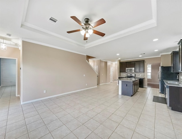 20015 Flax Flower Dr, Richmond, TX 77407 - kitchen with a raised ceiling, stainless steel appliances, open floor plan, ceiling fan, and crown molding