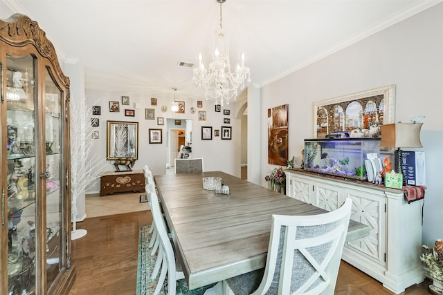 18115 Stone Angel Dr, Humble, TX 77346 - dining space featuring a chandelier, crown molding, wood finished floors, and arched walkways
