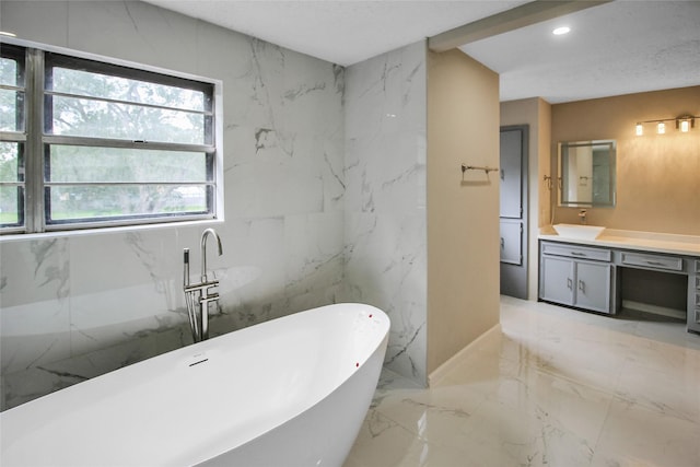 15102 Torry Pines Rd, Houston, TX 77062 - full bathroom with vanity, marble tiled flooring, a soaking tub, recessed lighting, and stone wall