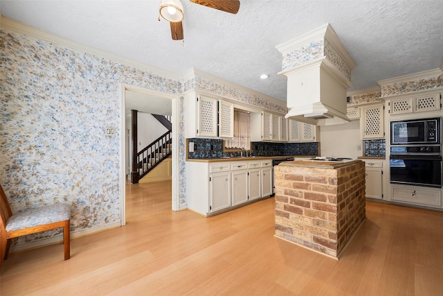 12223 Gladewick Dr, Houston, TX 77077 - kitchen featuring black appliances, light wood finished floors, ceiling fan, crown molding, and decorative backsplash