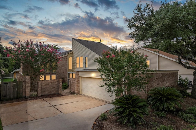 12223 Gladewick Dr, Houston, TX 77077 - view of front of house with an attached garage, concrete driveway, and brick siding