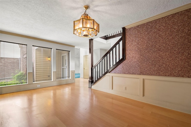 12223 Gladewick Dr, Houston, TX 77077 - foyer featuring ornamental molding, a chandelier, wood finished floors, stairs, and wainscoting