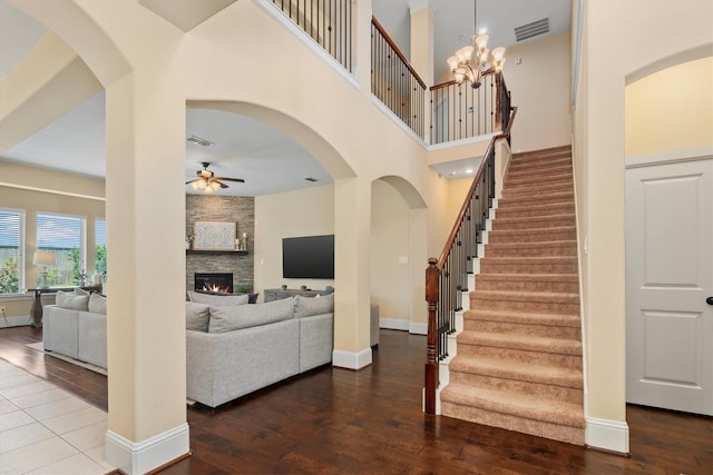 12919 Arlington Meadows Ln, Tomball, TX 77377 - staircase featuring a ceiling fan, a stone fireplace, hardwood / wood-style floors, and arched walkways