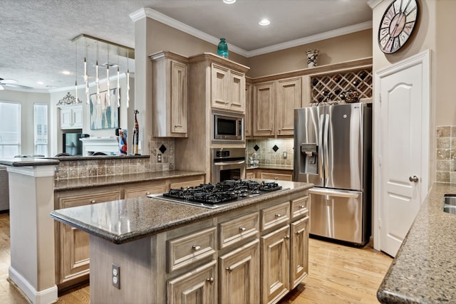 5706 Blossom St, Houston, TX 77007 - kitchen featuring stainless steel appliances, a kitchen island, decorative backsplash, light wood-type flooring, and a ceiling fan
