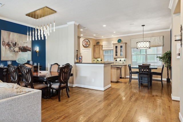 5706 Blossom St, Houston, TX 77007 - dining room with light wood-style floors, ornamental molding, recessed lighting, and a chandelier