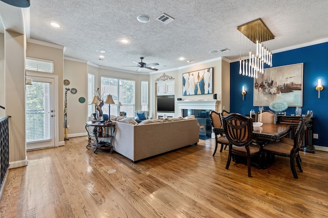 5706 Blossom St, Houston, TX 77007 - living room featuring ornamental molding, a textured ceiling, a tiled fireplace, wood finished floors, and ceiling fan