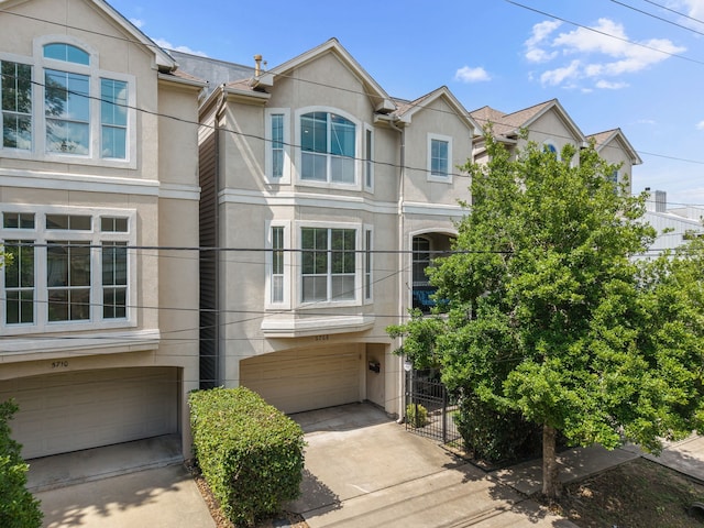 5706 Blossom St, Houston, TX 77007 - townhome / multi-family property featuring a garage, stucco siding, and driveway