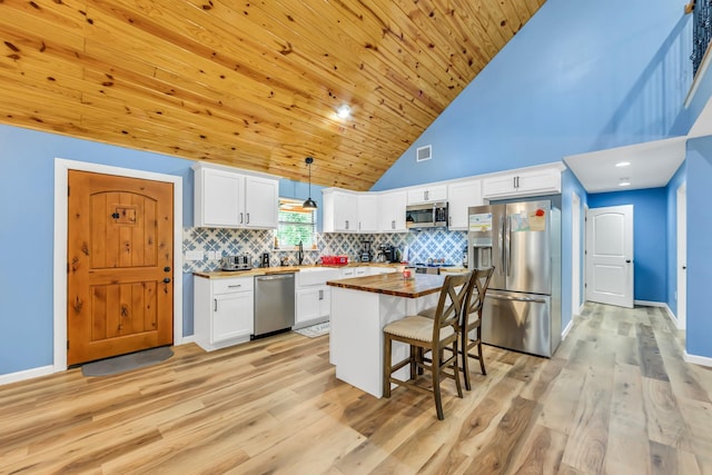 4214 Cross Cut, Cleveland, TX 77328 - kitchen featuring appliances with stainless steel finishes, wood counters, high vaulted ceiling, white cabinetry, and light wood-style floors