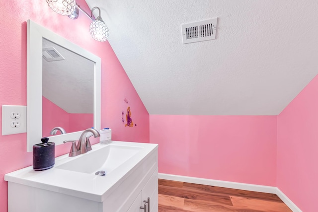 4214 Cross Cut, Cleveland, TX 77328 - bathroom featuring lofted ceiling, wood finished floors, vanity, and a textured ceiling