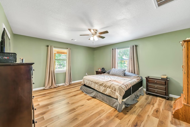 4214 Cross Cut, Cleveland, TX 77328 - bedroom with multiple windows, wood finished floors, a ceiling fan, and a textured ceiling