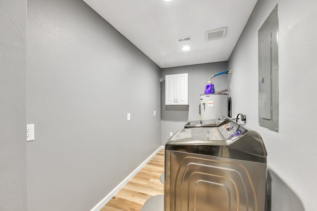 4214 Cross Cut, Cleveland, TX 77328 - laundry room featuring cabinet space, washing machine and clothes dryer, water heater, light wood-style floors, and electric panel
