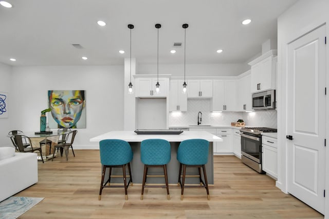 2610 Vance St, Houston, TX 77093 - kitchen featuring stainless steel appliances, a kitchen island, a breakfast bar area, light countertops, and tasteful backsplash