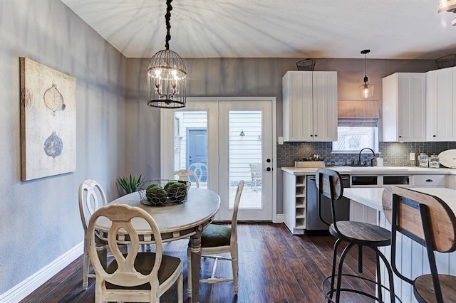 1023 Fountain View Dr, Houston, TX 77057 - kitchen with dark wood finished floors, light countertops, white cabinetry, a chandelier, and tasteful backsplash