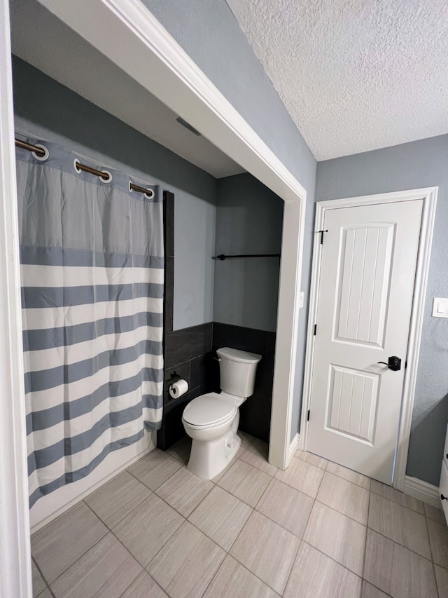 1023 Fountain View Dr, Houston, TX 77057 - full bath featuring a textured ceiling, tile patterned floors, and a shower with shower curtain