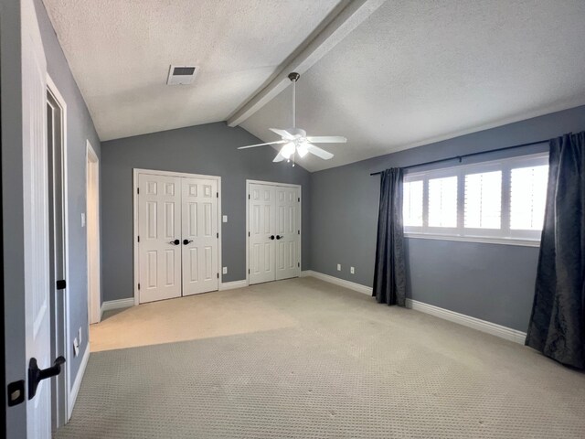 1023 Fountain View Dr, Houston, TX 77057 - unfurnished bedroom featuring two closets, light colored carpet, a textured ceiling, and ceiling fan