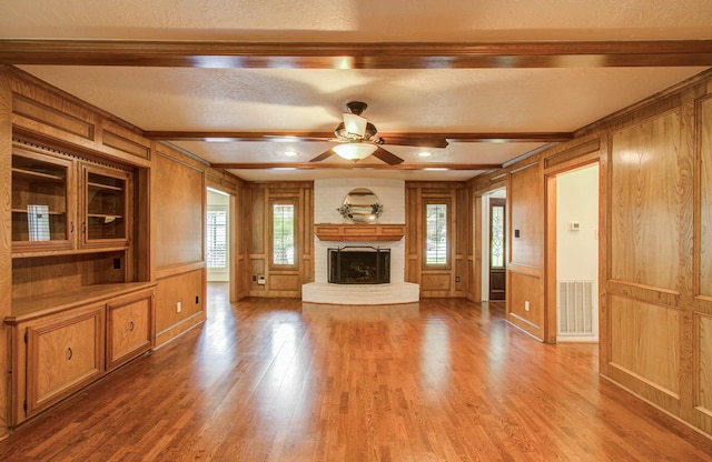 3623 Beech Hill Dr, Spring, TX 77388 - unfurnished living room featuring a decorative wall, wood finished floors, a fireplace, ceiling fan, and a textured ceiling