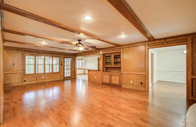 3623 Beech Hill Dr, Spring, TX 77388 - unfurnished living room featuring a decorative wall, beam ceiling, healthy amount of natural light, a textured ceiling, and a ceiling fan
