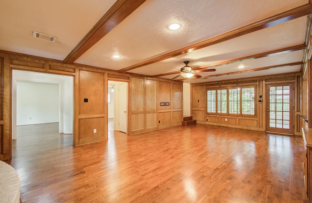 3623 Beech Hill Dr, Spring, TX 77388 - unfurnished living room featuring a ceiling fan, light wood-type flooring, beamed ceiling, a decorative wall, and a textured ceiling