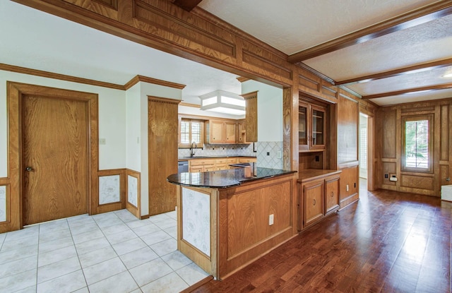3623 Beech Hill Dr, Spring, TX 77388 - kitchen with a peninsula, brown cabinetry, dark countertops, crown molding, and light wood-type flooring