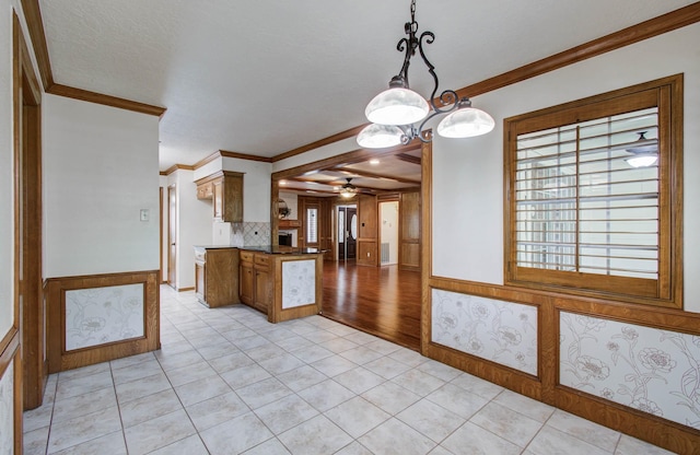 3623 Beech Hill Dr, Spring, TX 77388 - kitchen with ornamental molding, a ceiling fan, light tile patterned floors, brown cabinets, and wainscoting