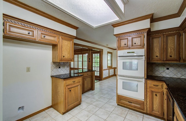 3623 Beech Hill Dr, Spring, TX 77388 - kitchen with double oven, tasteful backsplash, brown cabinets, ornamental molding, and light tile patterned floors