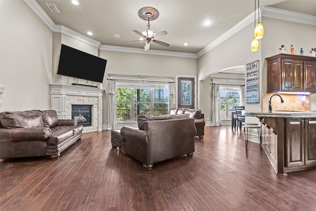 1207 Marigold Ln, Longview, TX 75604 - living room featuring a ceiling fan, arched walkways, a stone fireplace, dark wood-style flooring, and recessed lighting