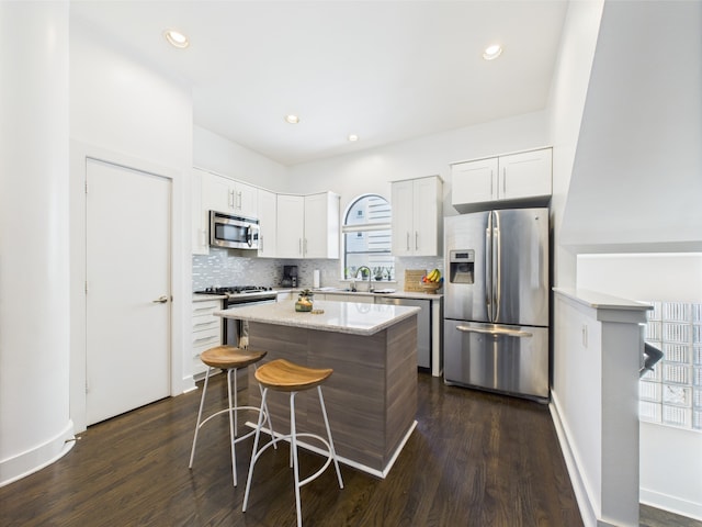 5810 Darling St Unit F, Houston, TX 77007 - kitchen with appliances with stainless steel finishes, tasteful backsplash, dark wood-type flooring, a center island, and recessed lighting