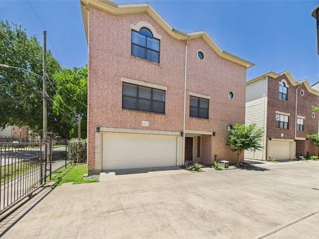 5810 Darling St Unit F, Houston, TX 77007 - view of front facade with an attached garage, driveway, and brick siding
