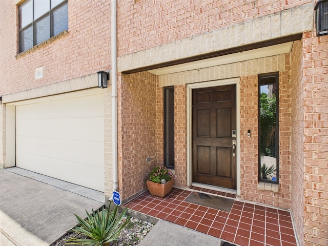 5810 Darling St Unit F, Houston, TX 77007 - doorway to property featuring a garage, brick siding, and driveway