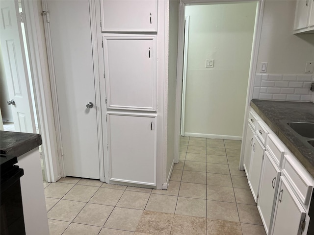 23114 Earlmist Dr, Spring, TX 77373 - kitchen with dark countertops, white cabinets, light tile patterned floors, and stove