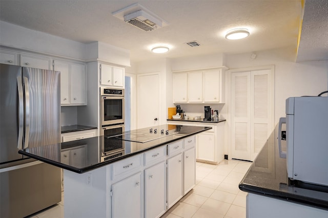 10730 Braes Bayou Dr, Houston, TX 77071 - kitchen with freestanding refrigerator, black electric stovetop, white microwave, white cabinets, and a textured ceiling