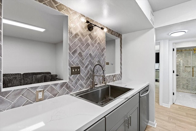 3220 69th St Unit E4, Galveston, TX 77551 - kitchen featuring gray cabinetry, stainless steel dishwasher, tasteful backsplash, and light stone counters