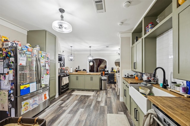 31730 Waller Tomball Rd, Waller, TX 77484 - kitchen featuring wood counters, green cabinetry, stainless steel appliances, wood finished floors, and crown molding