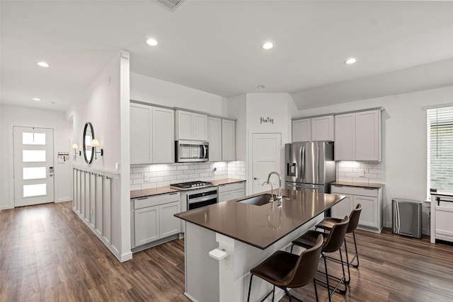 14320 Yellow Hawthorn Ct, Conroe, TX 77384 - kitchen with stainless steel appliances, healthy amount of natural light, dark wood-style floors, decorative backsplash, and recessed lighting