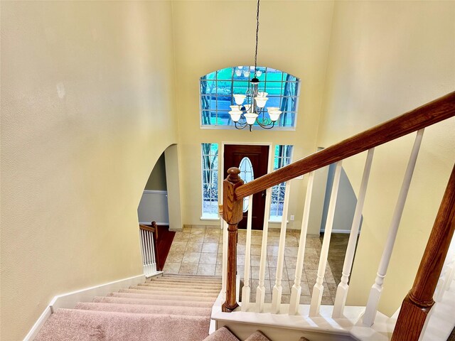 2716 W Oaks Cir E, Pearland, TX 77584 - stairway with a chandelier, a towering ceiling, and arched walkways