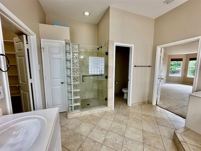 2716 W Oaks Cir E, Pearland, TX 77584 - bathroom with a stall shower, tile patterned flooring, vanity, a walk in closet, and recessed lighting