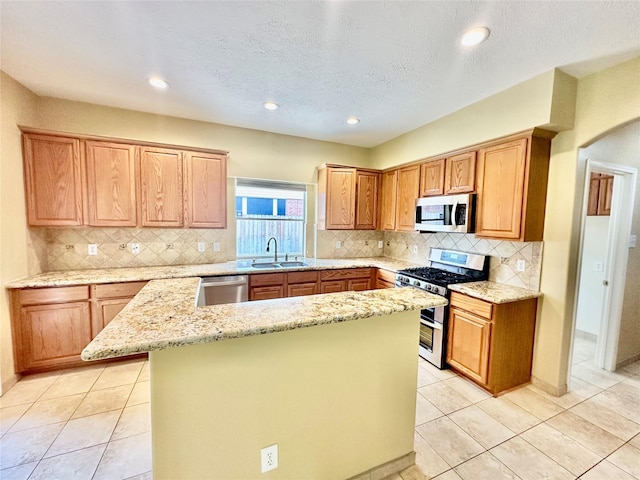 2716 W Oaks Cir E, Pearland, TX 77584 - kitchen featuring appliances with stainless steel finishes, a kitchen island, light stone counters, backsplash, and recessed lighting