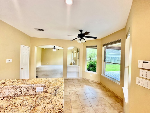 2716 W Oaks Cir E, Pearland, TX 77584 - kitchen featuring ceiling fan, arched walkways, and light tile patterned flooring