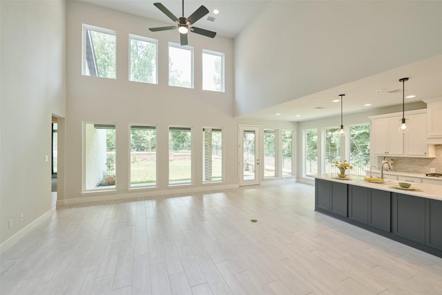 237 Patina Sorrel Dr, Montgomery, TX 77316 - kitchen featuring light countertops, open floor plan, ceiling fan, white cabinetry, and plenty of natural light