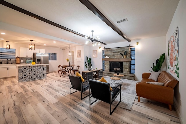 5918 Lattimer Dr, Houston, TX 77035 - living room with light wood-style floors, beam ceiling, a chandelier, recessed lighting, and a fireplace