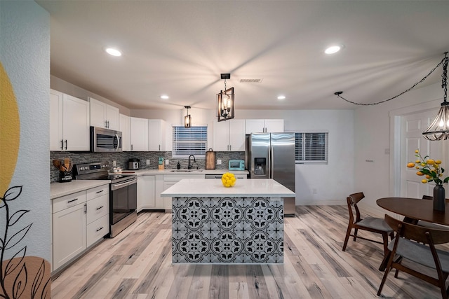 5918 Lattimer Dr, Houston, TX 77035 - kitchen with stainless steel appliances, tasteful backsplash, light wood-style flooring, light countertops, and a center island